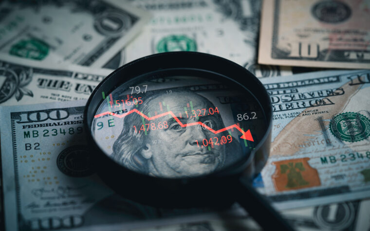 Red down arrow inside of magnifier glass and USD dollar banknote for United States of America or USA economic recession crisis and Fed reduce interest concept.